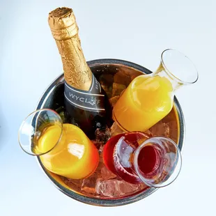 a bucket of fruit and a bottle of champagne