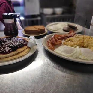 a breakfast of pancakes, eggs, bacon, and jam