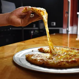 a hand holding a slice of pizza