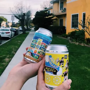 two cans of beer in front of a house