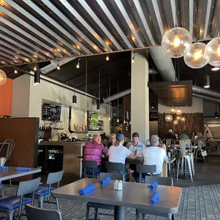 Interior of restaurant towards the entrance, bar, and bathrooms. Modern, minimalist, trendy vibes.