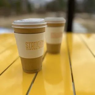 two cups of coffee on a yellow table