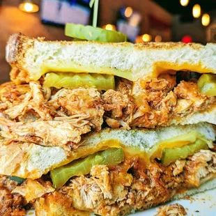 Buffalo Melt: Shredded chicken tossed in our house made Buffalo sauce, topped with Gouda, cheddar, and pickles. Served with choice of side.