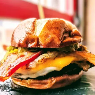 Sink your teeth into the Kristopher Johnathon Burger-topped with mozzarella, smoked Gouda, cheddar, grilled onions, and bacon!