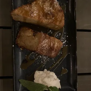 two pieces of bread on a black plate