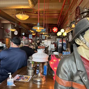 a statue of a fireman sitting at a bar