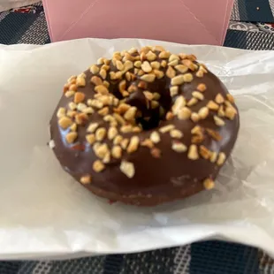 a chocolate donut with nuts on top
