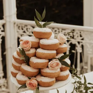 a tower of donuts with icing and flowers