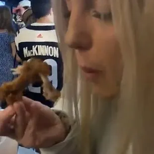 a woman eating a donut and drinking a beer