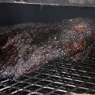 a large piece of meat cooking on a grill