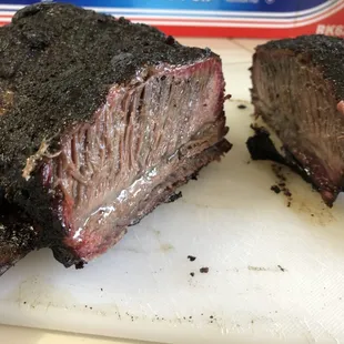 two pieces of beef on a cutting board