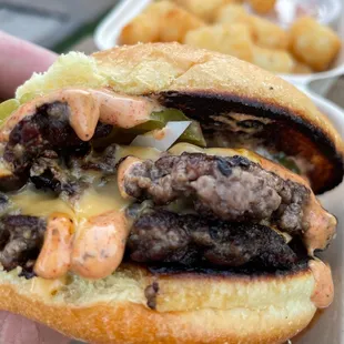 a hand holding a hamburger