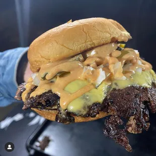 a hand holding a hamburger