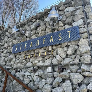 a sign on a stone wall