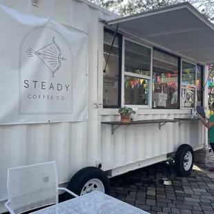a woman standing in front of a food truck