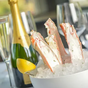 a bowl of crab legs and a bottle of champagne