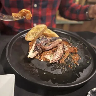a man holding a fork over a plate of food