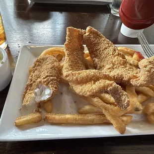 Fried catfish and fries with their own tartar sauce on the side.