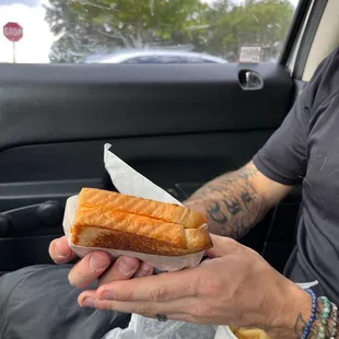  a man in a car eating a sandwich