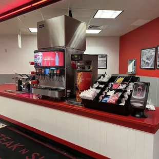 Self service drink fountain with scanner.  Also ketchup, napkins, straws, salt and pepper.