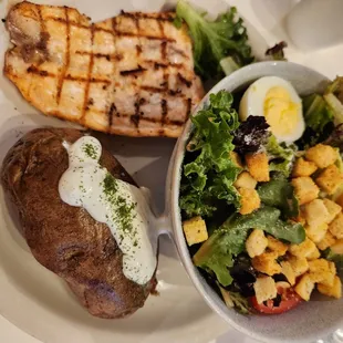 a plate of food with a salad and a baked potato