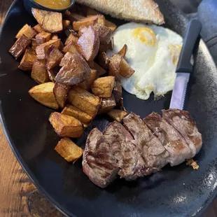 The classic Steak &amp; eggs, sour dough toast, side of green chili and a load of breakfast potatoes!