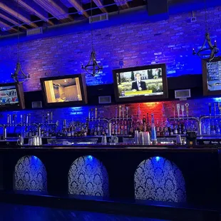 a bar with multiple televisions on the wall