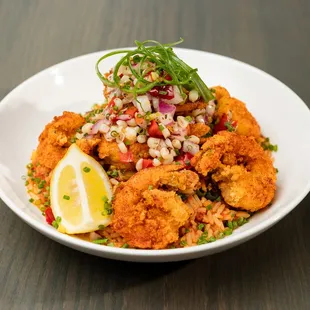 a plate of fried food with a lemon wedge