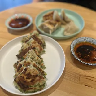 a plate of dumplings and sauces