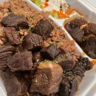 Rice and beans (Waakye/ Ayimolu) with fried beef and a side salad and boiled egg swimming in the best sauce
