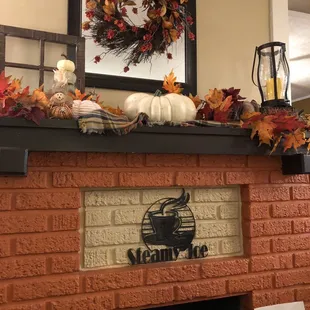 a brick fireplace decorated for fall
