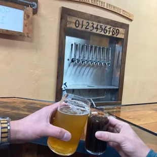 two people holding glasses of beer