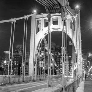 a man walking across a bridge at night