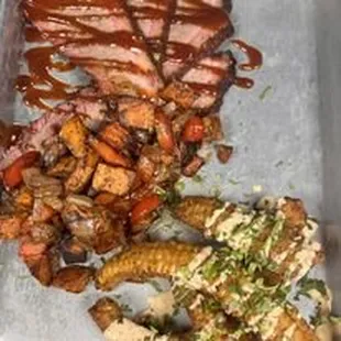 a tray of food including meat and vegetables