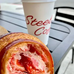 a croissant sandwich and a cup of coffee