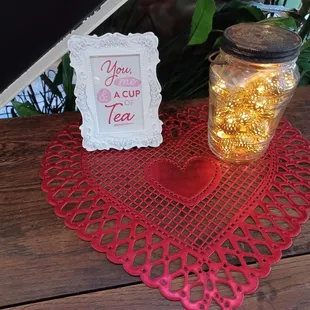 a jar of tea and a heart shaped doily