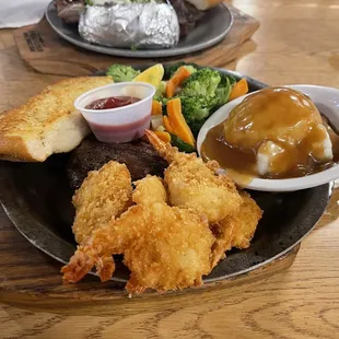 Steak and shrimp with veggie and mashed potato side.