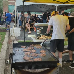a man cooking burgers on a grill