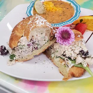 a chicken salad sandwich with a side of fruit