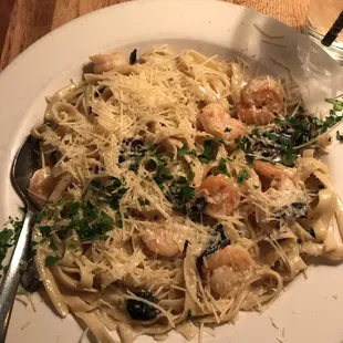 a plate of pasta with shrimp and mushrooms