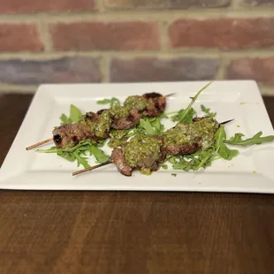 skewered meat on a white plate