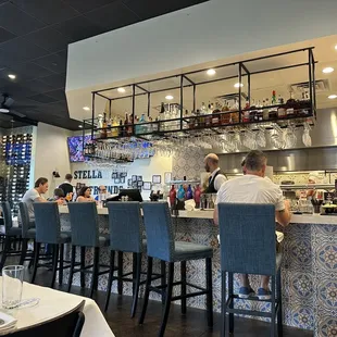 a restaurant with people sitting at the bar