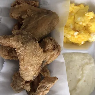 a plate of fried chicken, eggs, and mashed potatoes