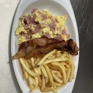 Revuelto con jamón dentro y tocino al lado y papas fritas  Scrambled with ham mixed in and bacon on the side and French fries