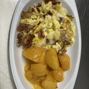 Scrambled eggs with bacon mixed in and Swiss cheese and house potatoes  Revuelto con tocino dentro y queso suizo y papas de la casa