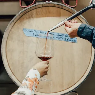 a woman pouring wine into a glass