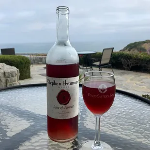 a glass of wine and a bottle on a table