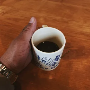 a hand holding a cup of coffee