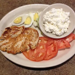 Grilled chicken breast on the low cal part of the menu served with tomatoes, eggs, and cottage cheese