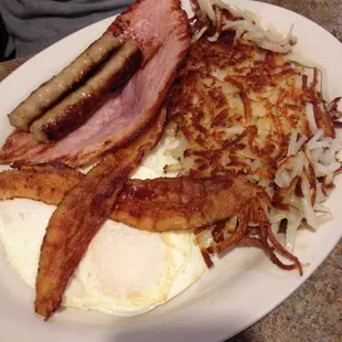 Bacon, eggs, sausage, has browns, ham and toast